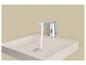 Robinet automatique chromé avec de l'eau qui coule dans un lavabo clair.