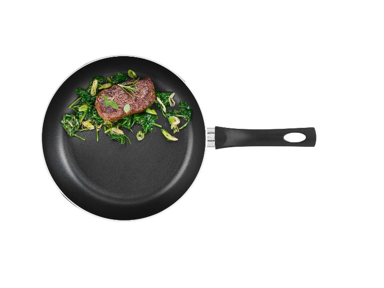 Un steak avec des épinards dans une poêle noire.
