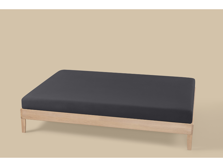 Un cadre de lit en bois avec un drap-housse gris foncé sur fond clair.