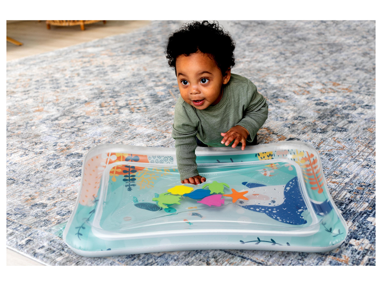 Bébé jouant avec un tapis d'eau gonflable à thème marin.