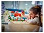 Fille jouant avec une maison LEGO Lilo & Stitch et des figurines.