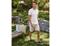Homme en polo blanc et short beige dans un jardin.