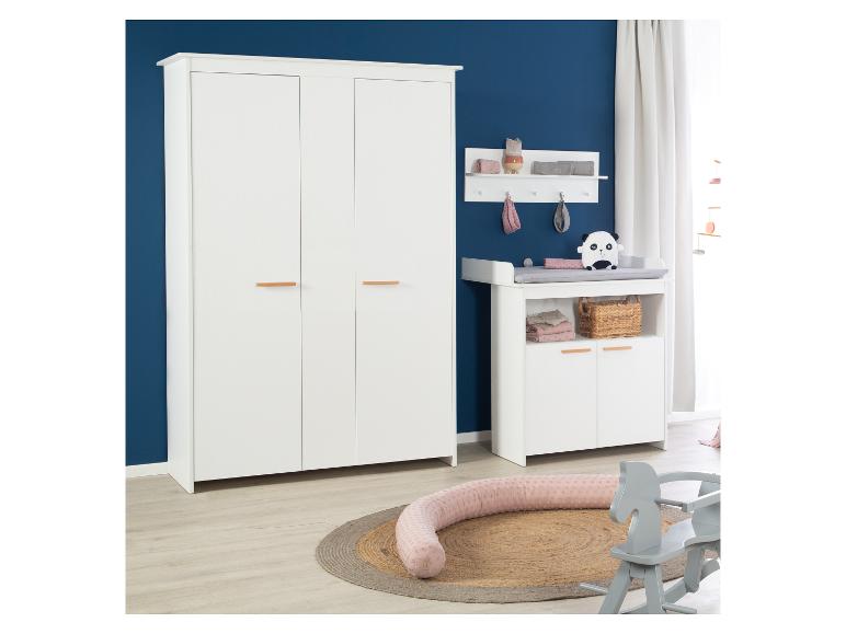 Chambre de bébé blanche avec armoire, table à langer et jouets sur un tapis.