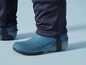 Bottes de pluie bleues avec des sangles noires et des jambes de pantalon noires.