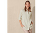 Une femme porte une chemise à manches longues de couleur vert clair.