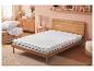 Protège-matelas sur un lit en bois dans une chambre claire.