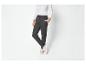 Pantalon de survêtement gris foncé avec des baskets blanches.
