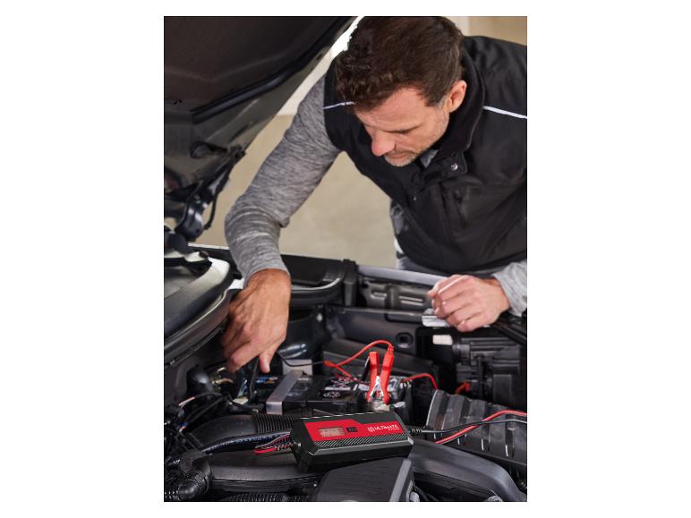 Homme connectant un chargeur de batterie Ultimate Speed à une voiture.