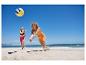 Deux femmes jouent au volley-ball sur la plage.