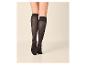 Jambes de femme en chaussettes montantes noires avec semelle antidérapante.