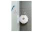 Aspirateur robot blanc sur carrelage gris avec des taches roses