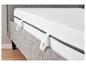 Un matelas gris avec un cadre gris et une bande blanche pour le transport.