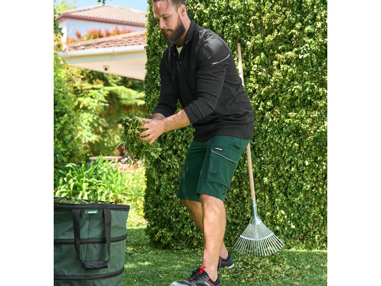 Un homme ramasse des feuilles dans le jardin avec un râteau et un sac à déchets Parkside.