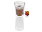 Un cappuccino dans une tasse en verre avec des mini gâteaux et des framboises.