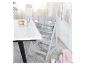 Chaise haute Stokke Tripp Trapp grise claire dans une chambre d'enfant.