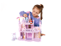 Fille jouant avec une maison de poupée rose et des figurines.