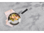 Filet de saumon aux légumes dans une poêle sur fond gris.