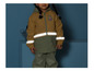 Un enfant porte un imperméable jaune avec des bandes réfléchissantes et un pantalon imperméable vert assorti.