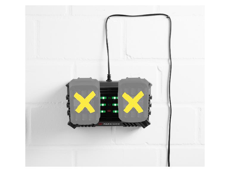 Chargeur avec deux batteries sur un mur de briques blanc.