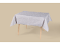 Nappe gris clair avec motif de sapins et flocons de neige sur une table en bois.