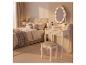 Coiffeuse blanche avec miroir éclairé et tabouret dans une chambre.