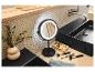 Miroir de maquillage lumineux, pinceaux et accessoires dans une salle de bain avec lavabo noir.