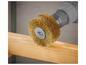 Une brosse métallique pour le travail du bois est utilisée sur une planche de bois.