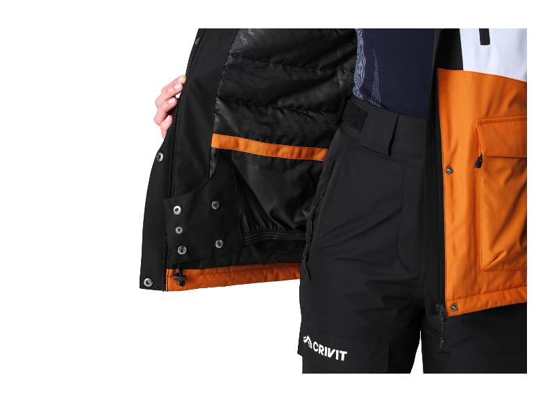 Gros plan d'une veste d'hiver noire et orange avec un pantalon noir.