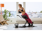 Femme faisant des extensions de dos avec un kettlebell sur un banc de musculation.