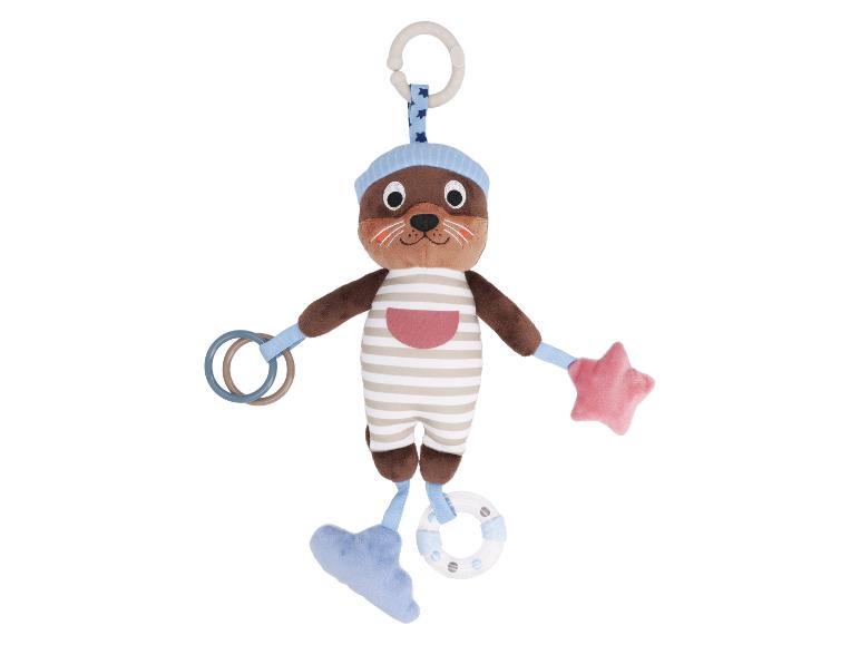 Peluche de loutre marron avec tenue rayée et divers jouets pour bébé attachés.