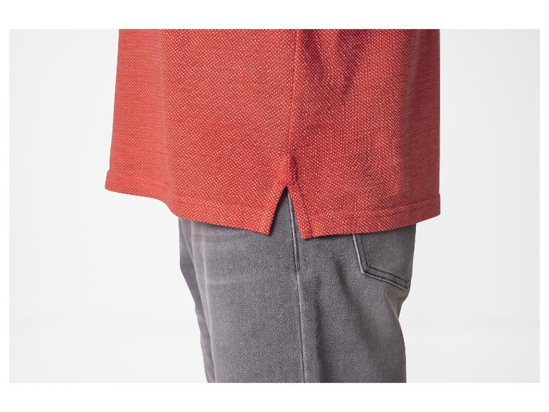 Polo rouge et jeans gris.