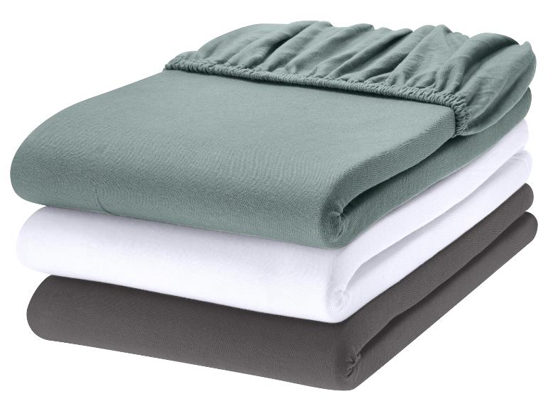 Pile de draps-housses en vert, blanc et gris.
