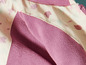Gros plan sur une veste en polaire rose avec une doublure claire à motif de feuilles.