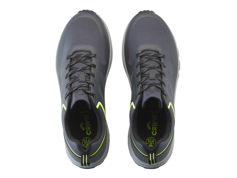 Deux baskets Crivit noires avec des accents verts.