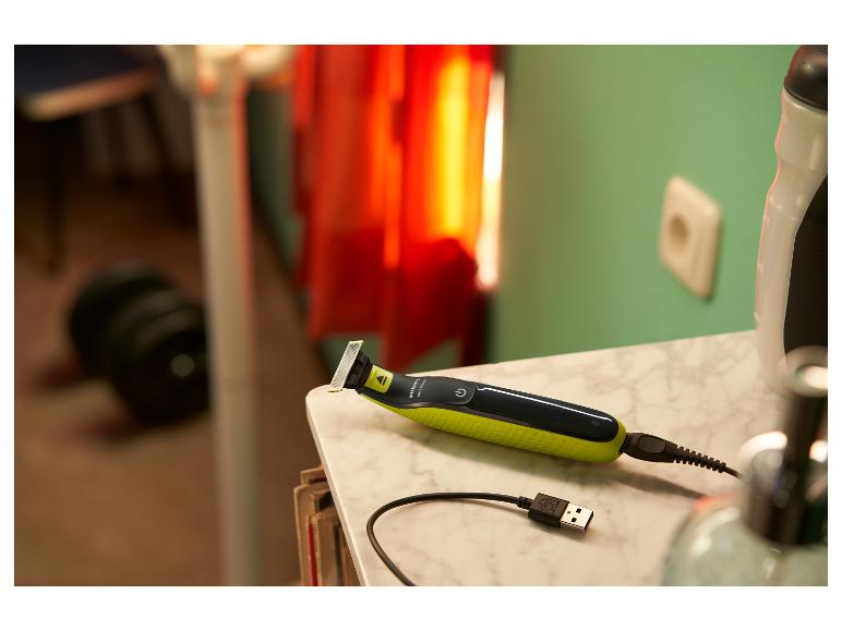 Rasoir électrique Philips OneBlade sur une table en marbre avec câble USB