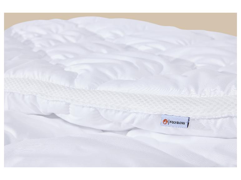 Détail d'un matelas blanc matelassé avec une bande en maille et une étiquette.