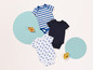 Vêtements de bébé avec des rayures, un design uni et un imprimé de bateaux.