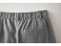 Gros plan sur la poche arrière et la taille élastique d'un pantalon gris.