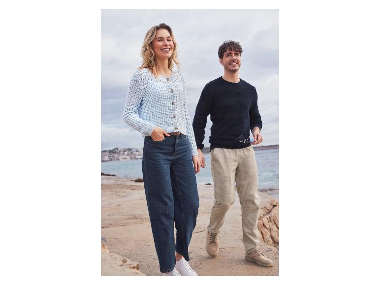 Une femme et un homme portent des vêtements décontractés, dont un pull en tricot et un jean.