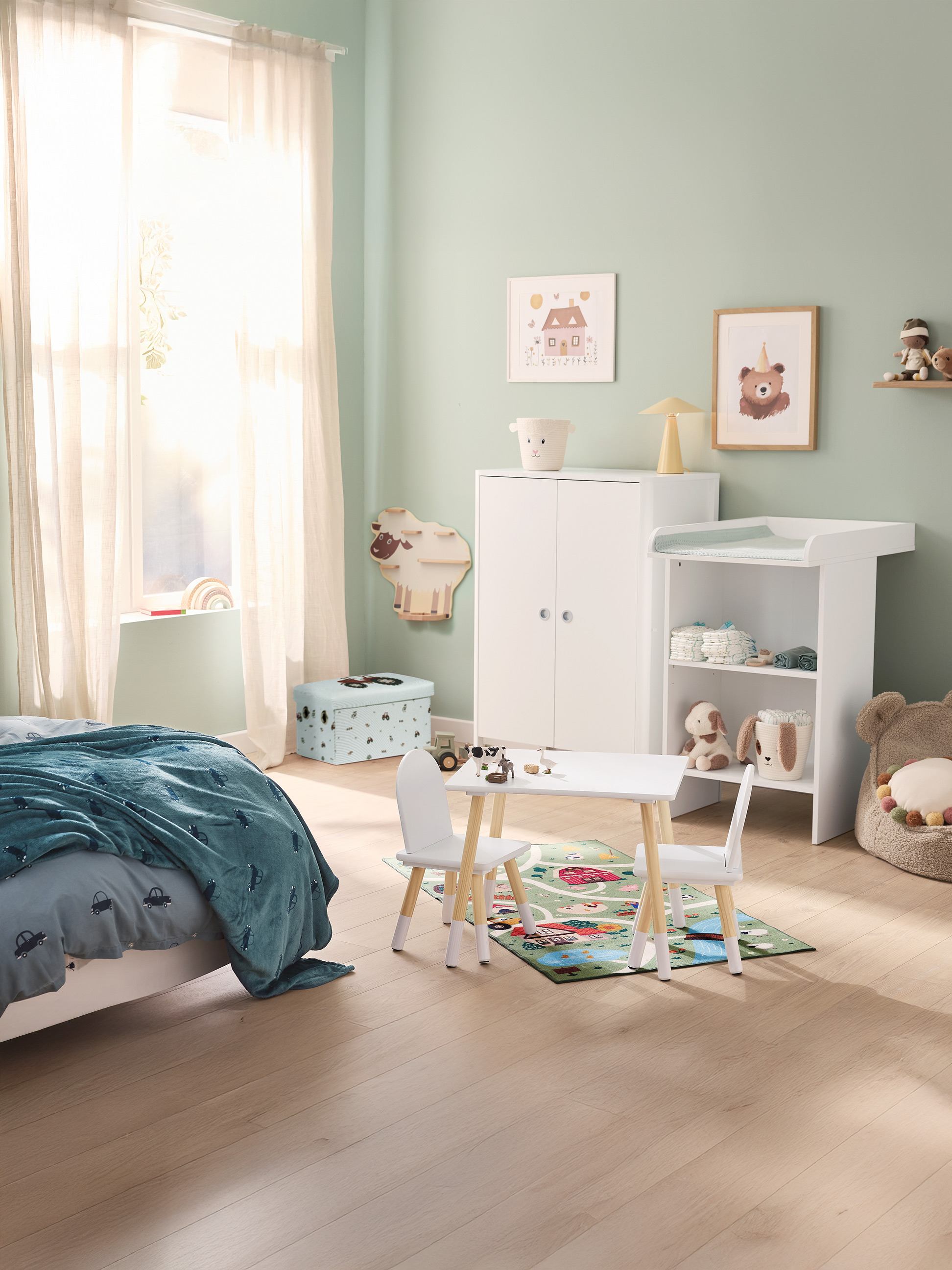Chambre d'enfant avec lit, table et chaises, table à langer et armoire, décorée de tons pastel.