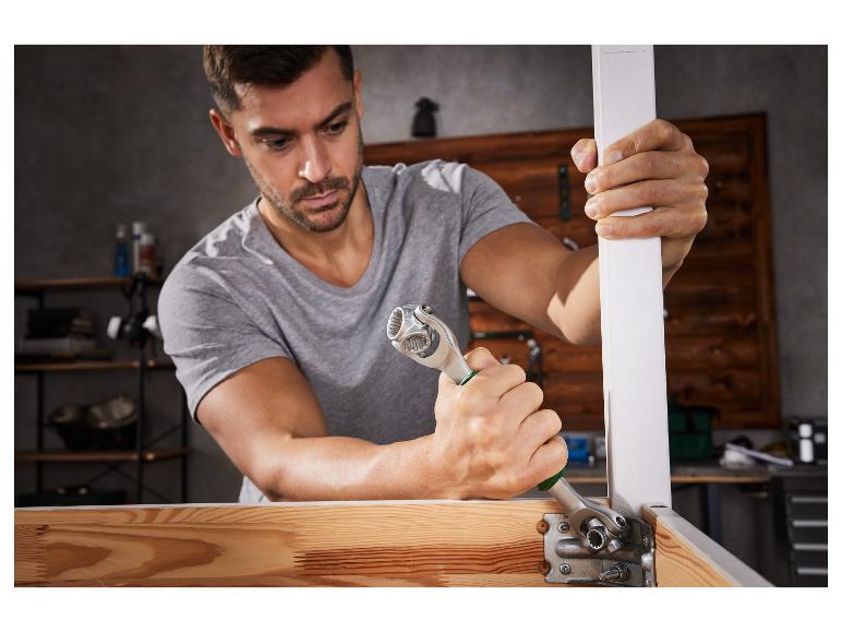 Un homme utilise une clé universelle pour assembler un meuble.