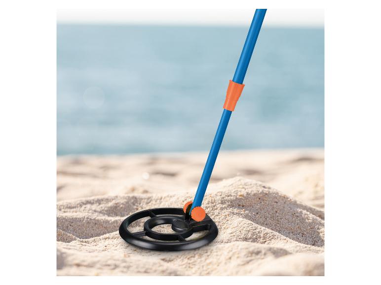 Détecteur de métaux sur une plage de sable avec l'océan en arrière-plan