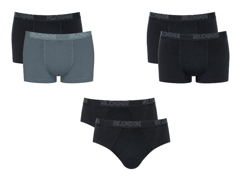 Trois ensembles de sous-vêtements pour hommes : deux ensembles de boxers (noir et gris, et tout noir) et un ensemble de slips noirs.