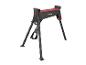 Un établi portable noir et rouge avec des pieds pliables, sur un fond blanc.