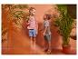 Deux enfants, une fille et un garçon, en vêtements d'été, t-shirts et shorts, parmi les plantes.