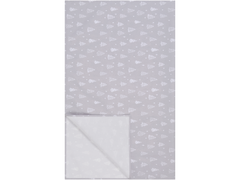 Nappe grise avec motif de sapins de Noël blancs et de flocons de neige, pliée en bas à gauche.
