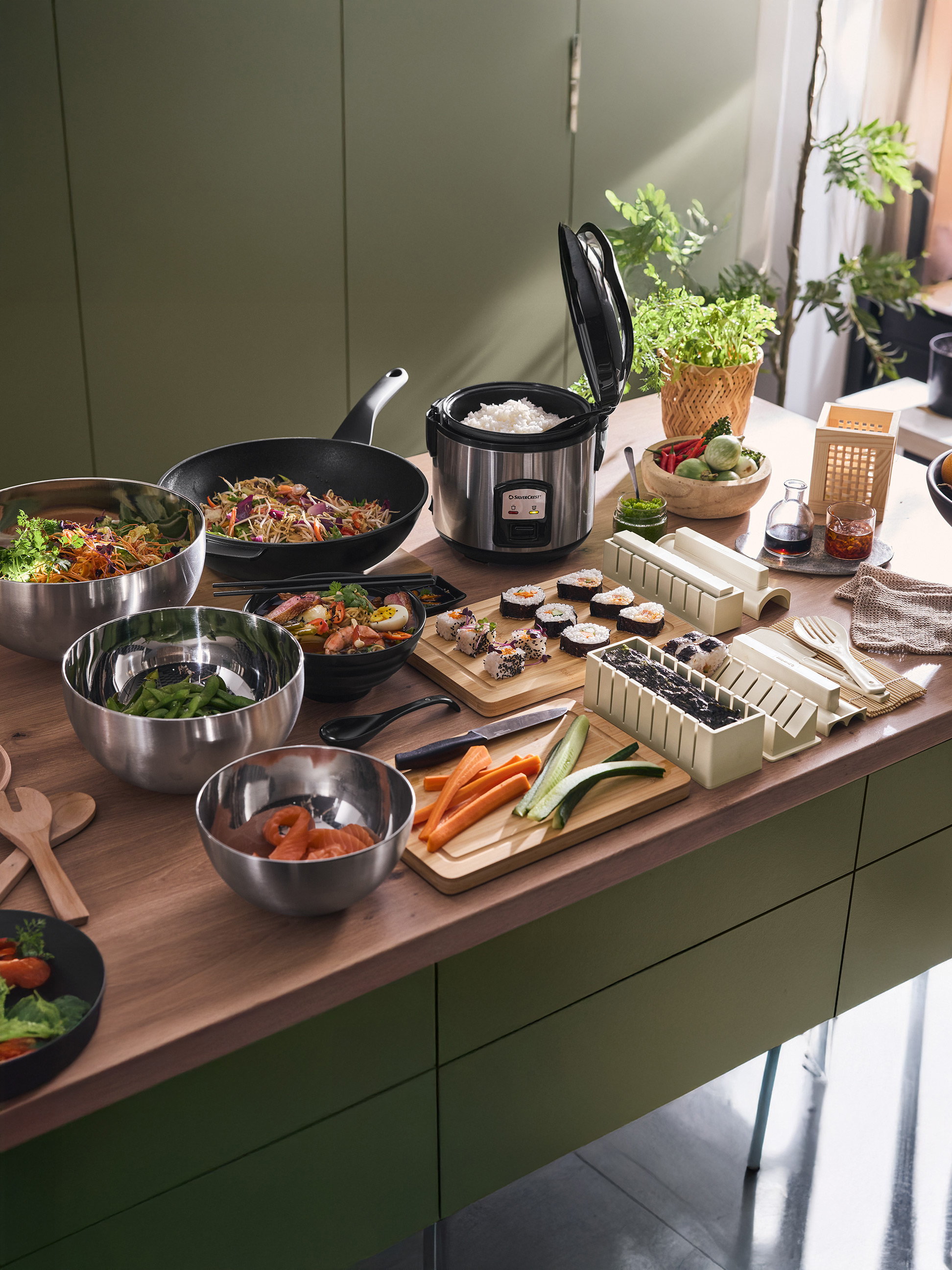 Cuisine asiatique avec cuiseur à riz SilverCrest, wok, sushis et bols de salade.