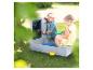 Enfants jouant avec un bac à sable en bois avec tableau dans un jardin.