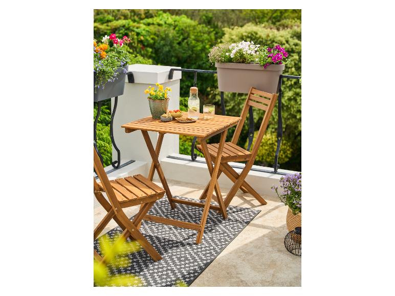 Table et chaises de balcon pliantes en bois avec plantes et boissons.