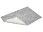 Nappe de table grise avec motif de feuilles, légèrement relevée sur un coin.